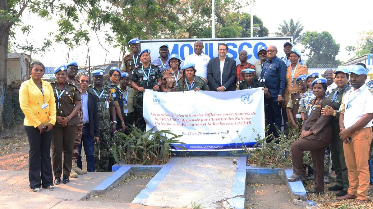 A group of peacekeepers standing together with a sign.